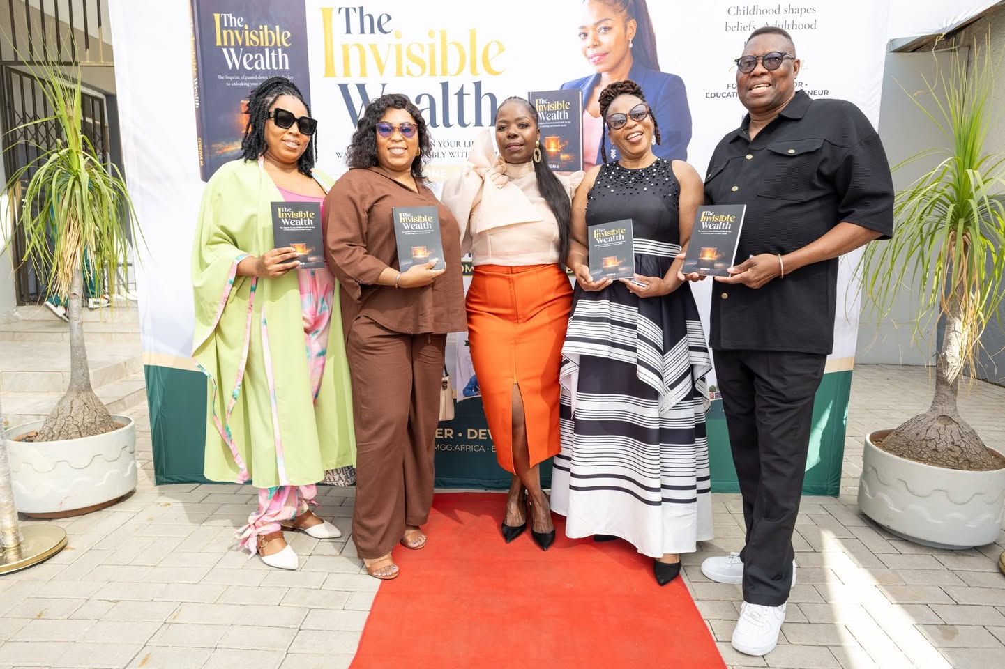 Guests holding copies of The Invisible Wealth at the book launch